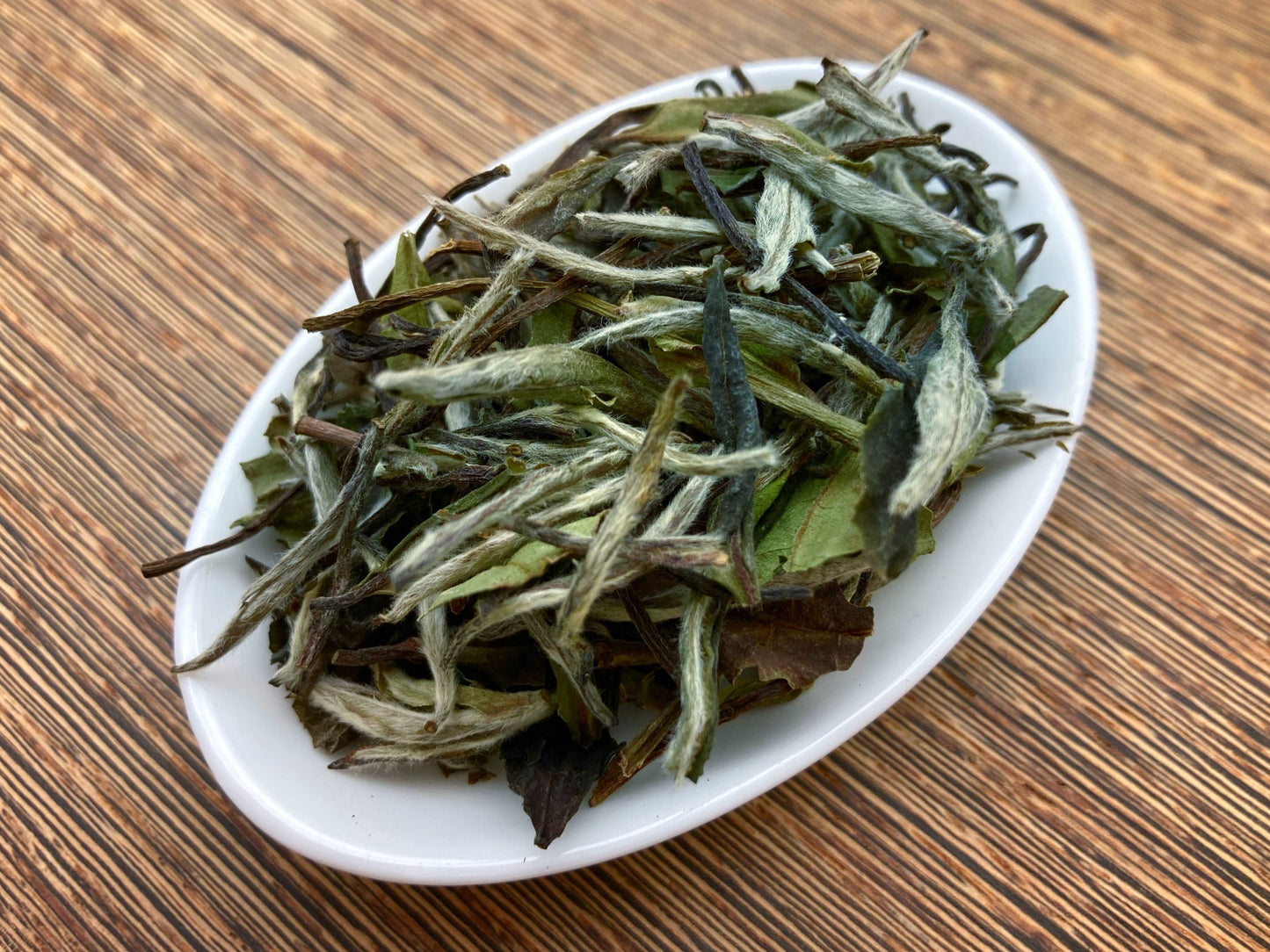 牡丹針王茶葉翠綠顯毫,條索勻整 | The loose leaves of Premium Grade Peony Tea exhibit a vibrant and lustrous green color, adorned with delicate fine hairs, showcasing their intact and pristine condition